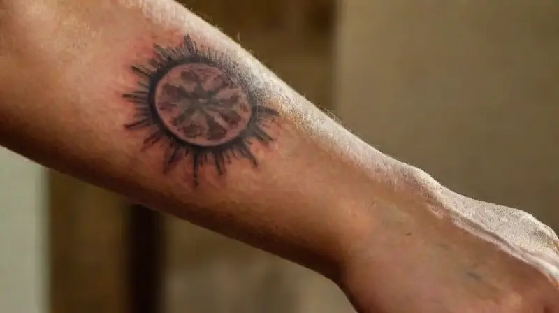 Sunlit arm with detailed tattoos and scars