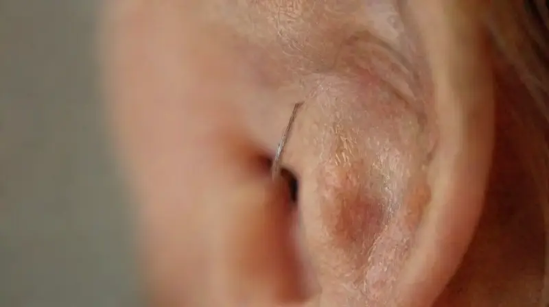 Close-up of womans ear with shiny hoop