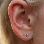 Close-up of realistic pierced ear with jewelry