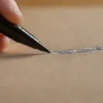 Close-up of hand writing with ink pen