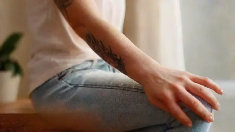 Fair-skinned arm with vibrant tattoo resting