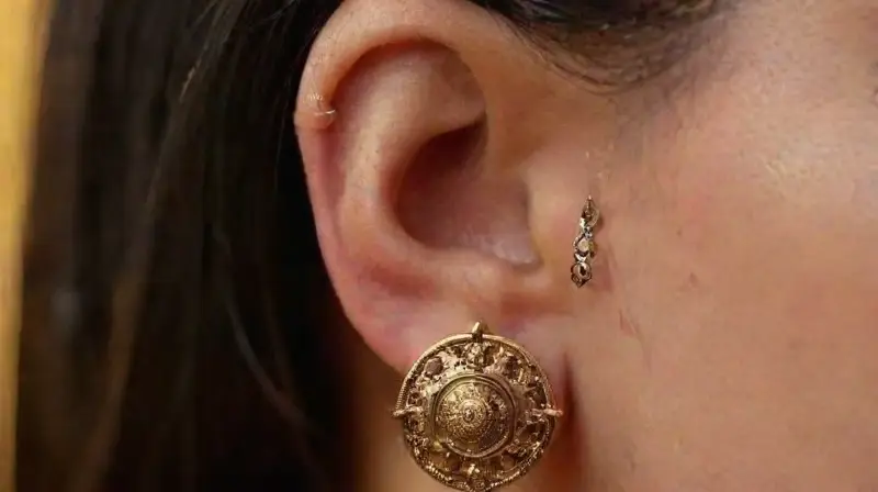Close-up of pierced ear with detailed jewelry