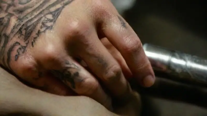 Close-up of tattooing hand and machine