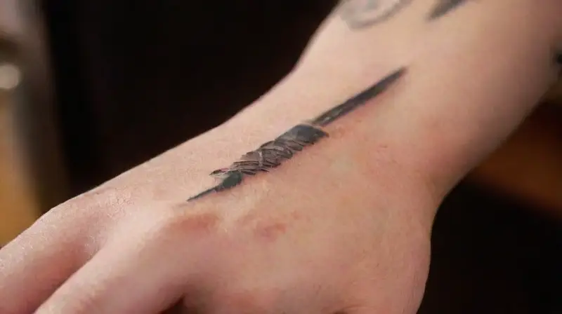 Close-up of hand tattooing with precision