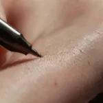 Close-up of hand with ink pen